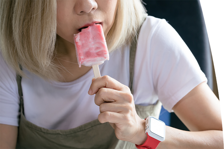 Woman eating ice pop while resting